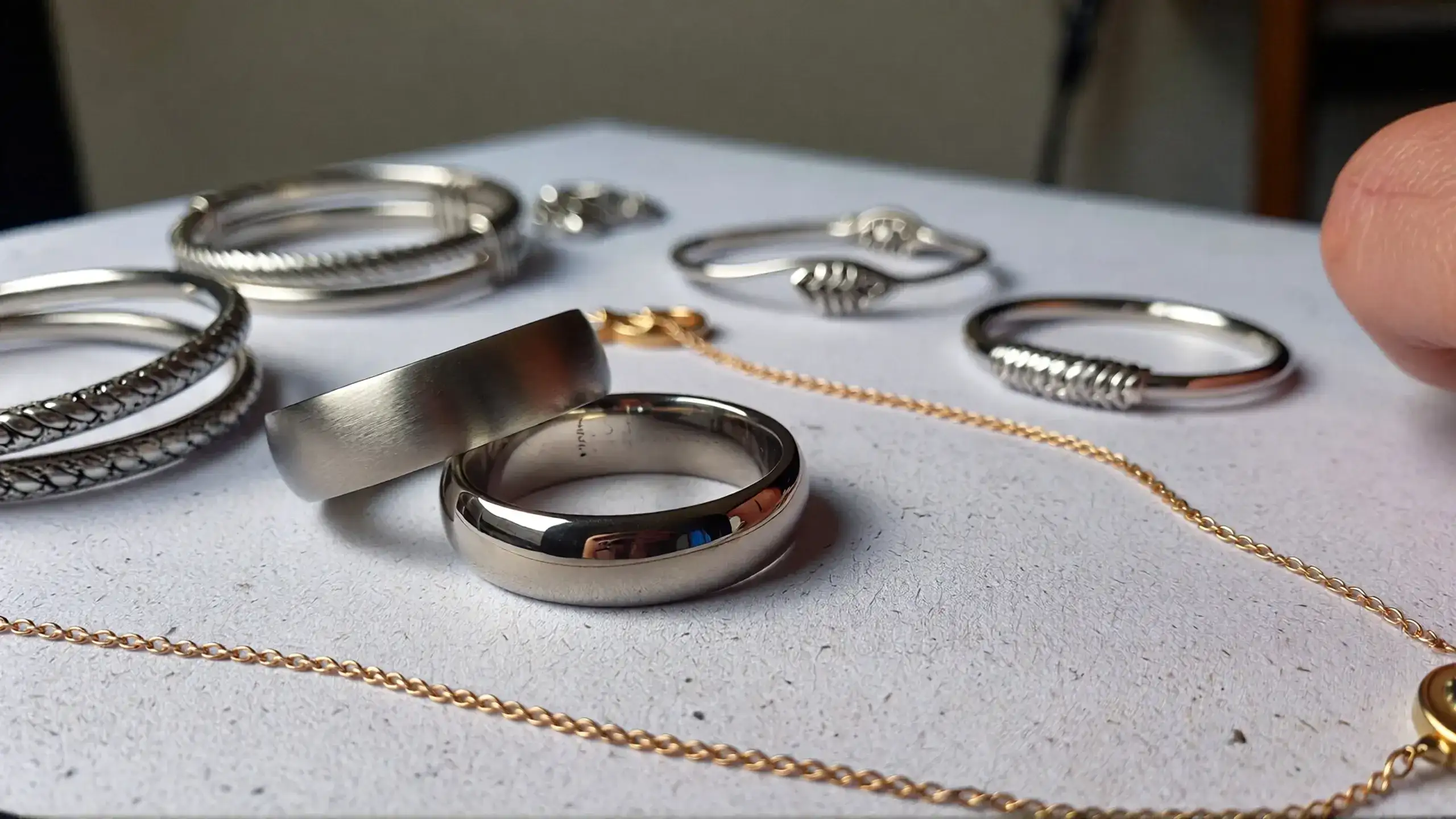 Assorted non-magnetic jewelry including titanium rings, gold necklace, and sterling silver bracelets safe for medical imaging_risultato