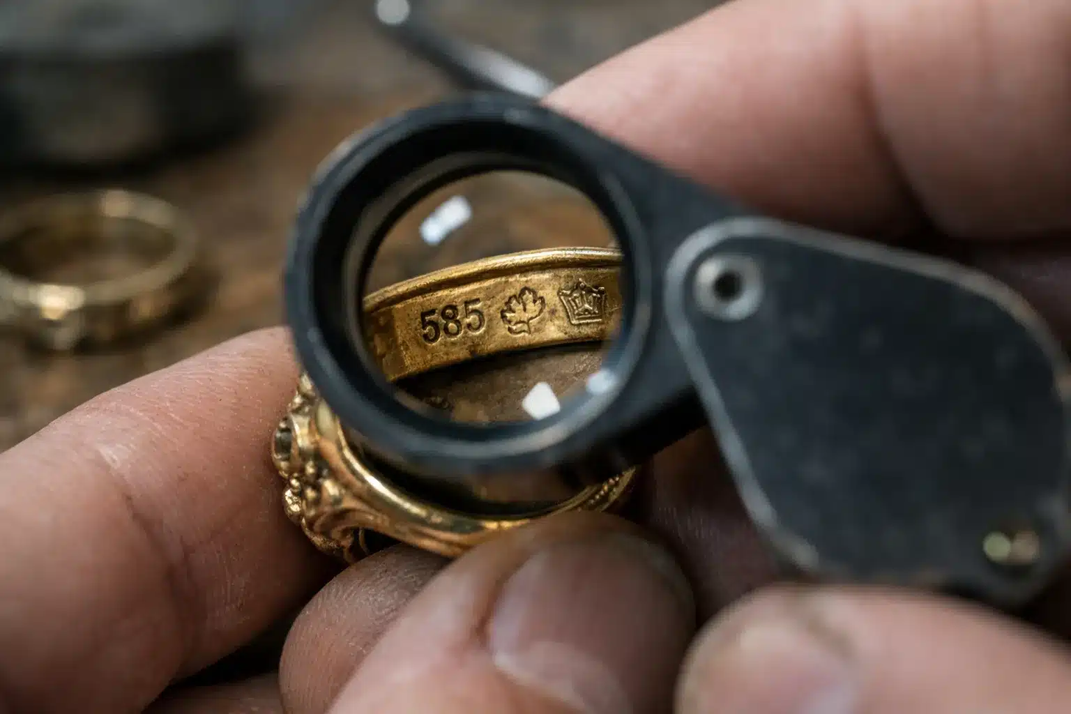 Using jewelers loupe to identify and authenticate German gold hallmarks on vintage ring risultato