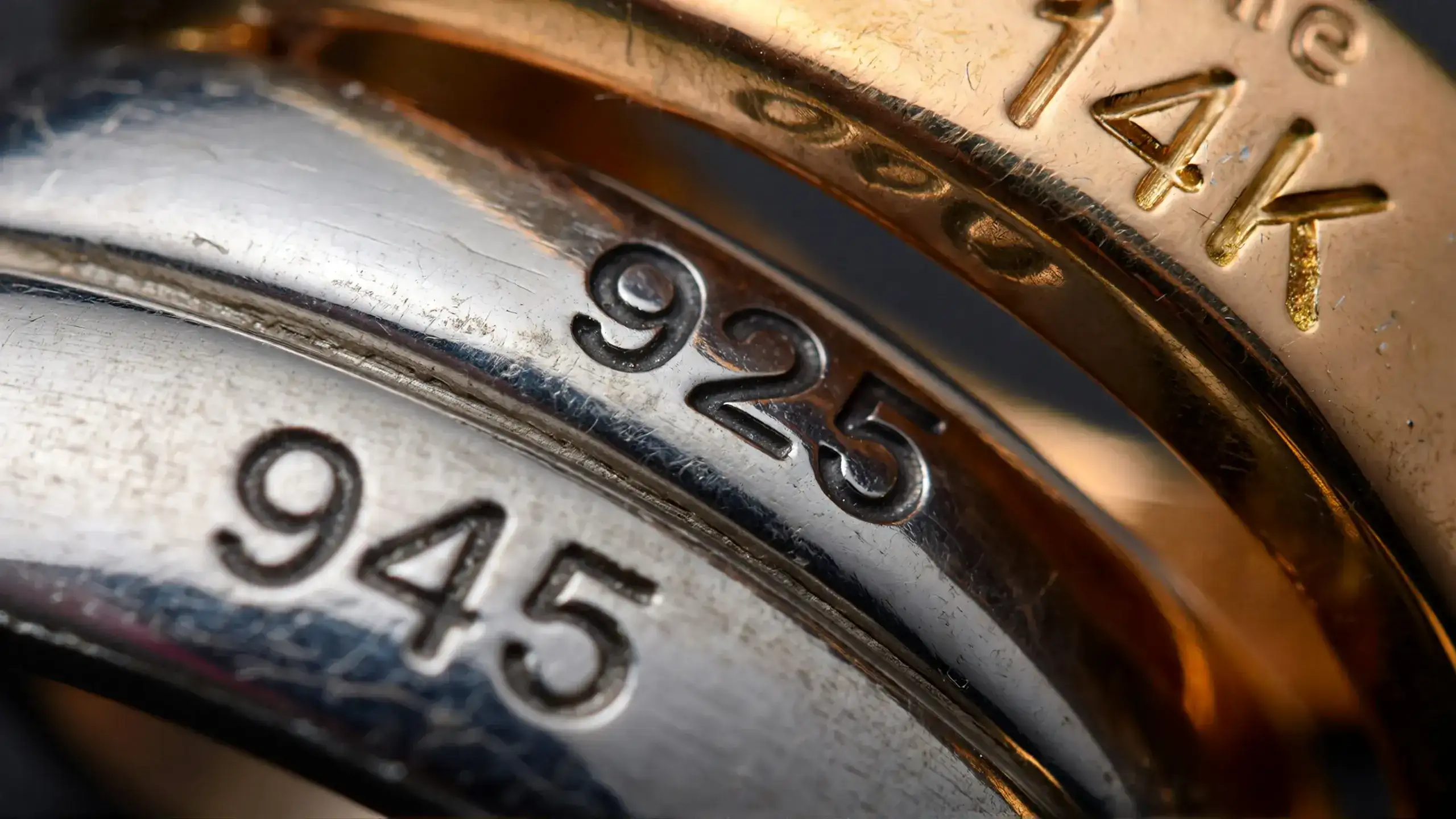 Magnified view of 925 sterling silver and 14K gold hallmarks stamped on jewelry for metal identification_risultato