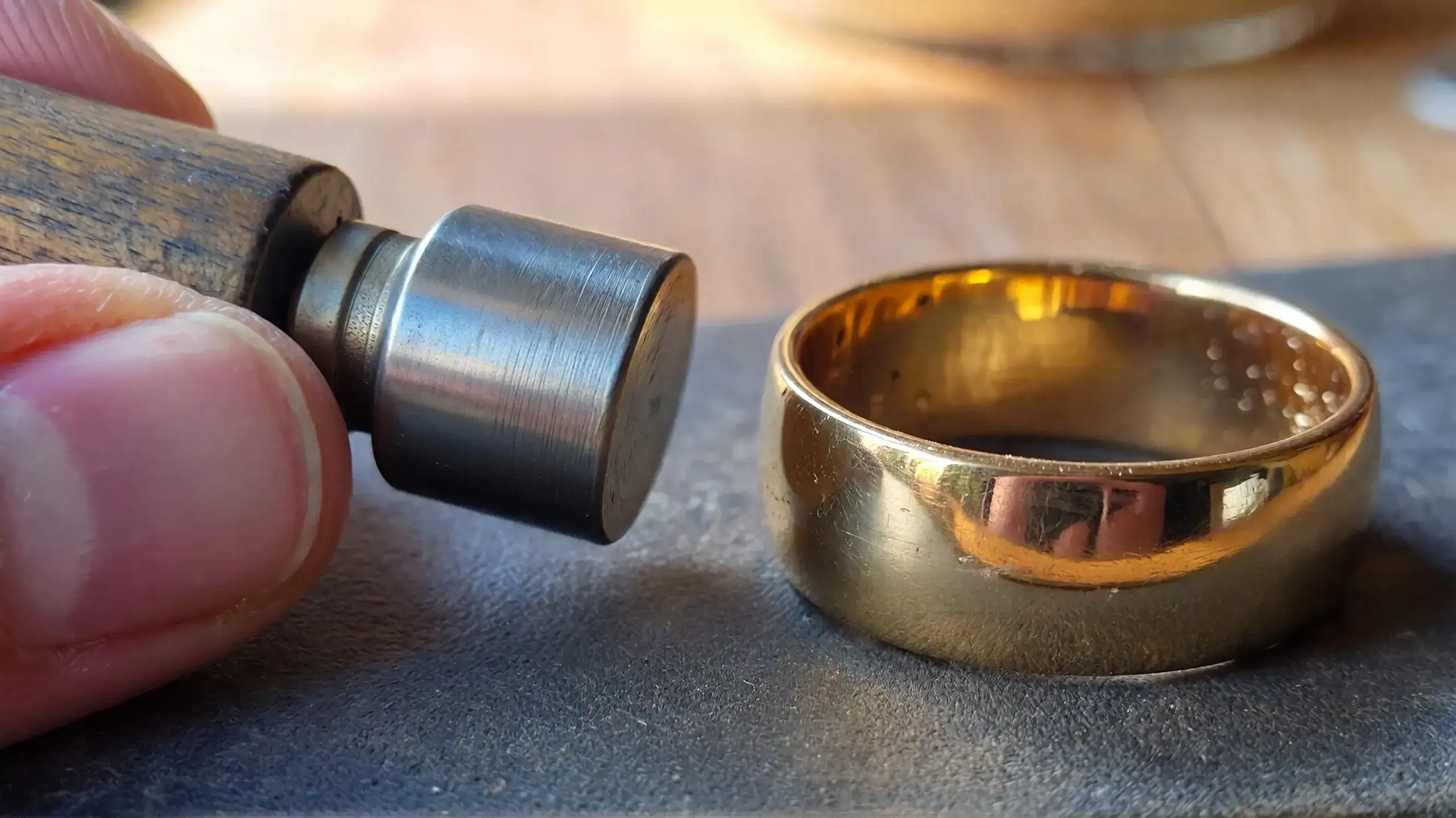 Neodymium rare earth magnet hovering above gold ring to test non-magnetic properties of precious metal jewelry_risultato