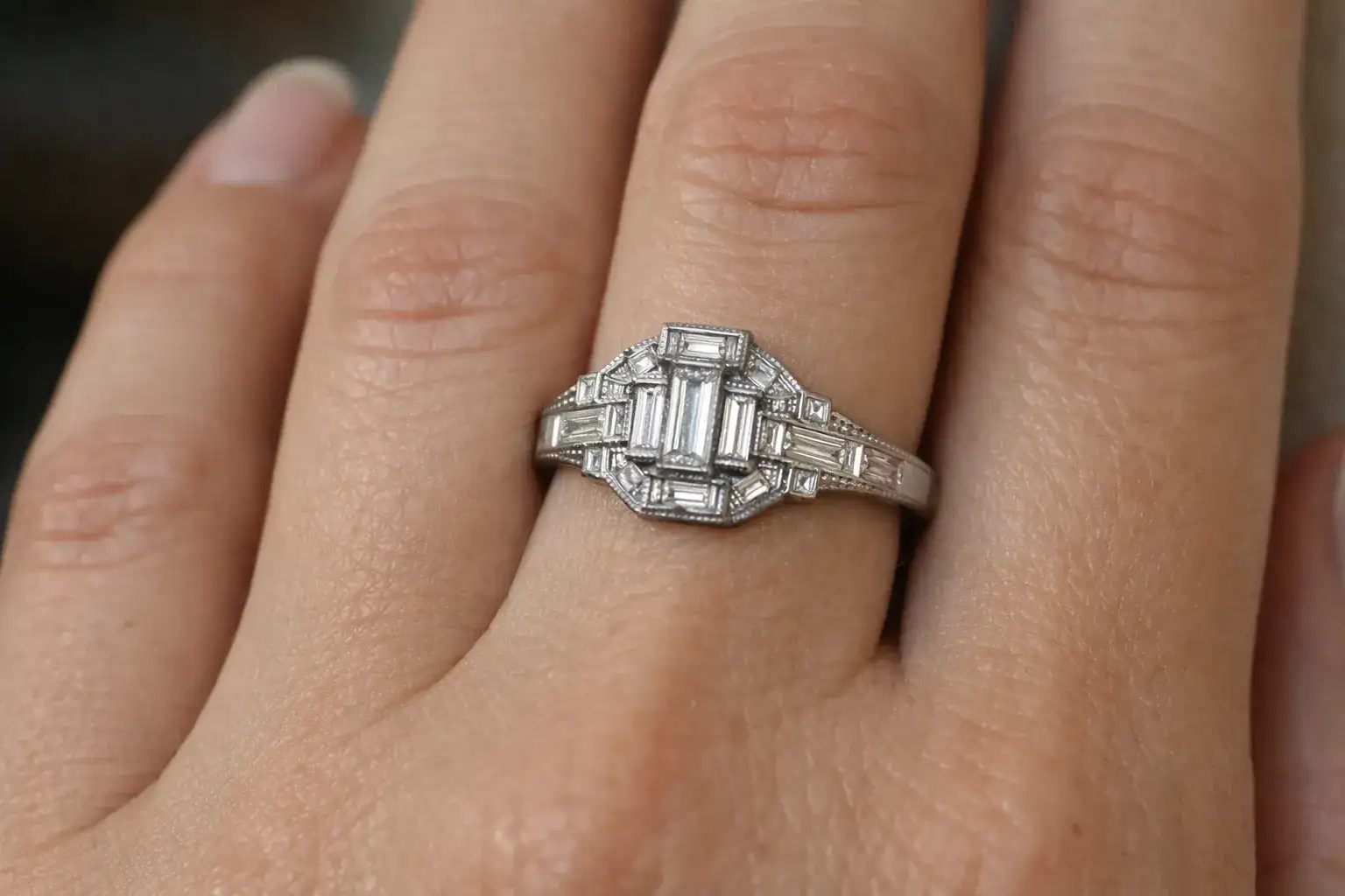 Art Deco wedding ring featuring geometric platinum design with baguette diamonds characteristic of 1920s-1930s style_risultato
